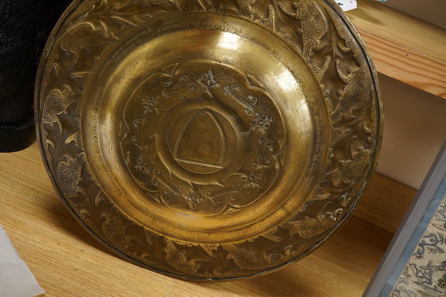 An embossed brass arts and crafts alms charger with inscriptions, 51cm in diameter
